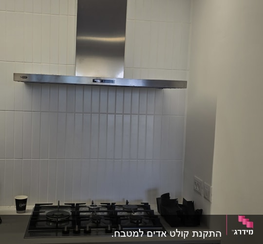 כיריים ומכסה נירוסטה במטבח מודרני